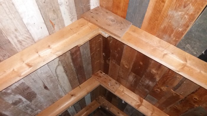 Träkonstruktionen av takstolar på en vind med synliga träbjälkar och lutande sparrar.