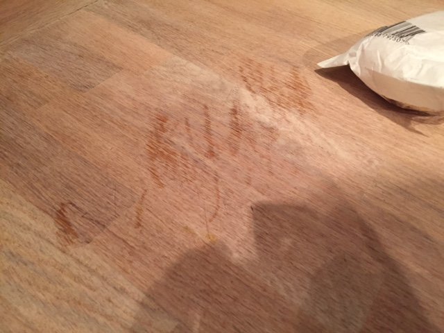 Sliten ek köksbänkskiva med flera missfärgade fläckar och synliga repor.