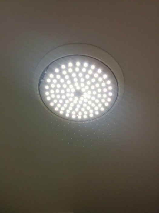 Takarmatur med LED-ljus tända på vit takyta, ingen modellnummer synlig.