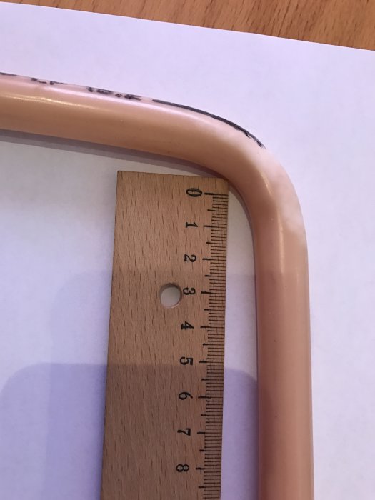 Flexrör med knixig böj bredvid linjal som visar dimension för byggprojekt.