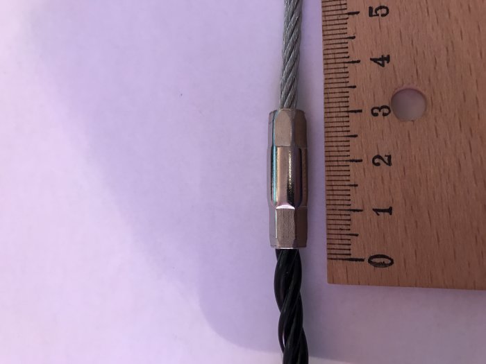 Metallhylsan på en dragfjäder bredvid ett linjal för storleksjämförelse.