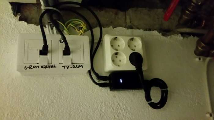 Nätverksinstallation i hemmet med ethernetkablar märkta för olika rum och PoE-injector.