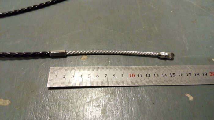 Dragfjäder för VP-rör vid sidan av en linjal på en grå yta, som visar fjäderns längd och storlek.