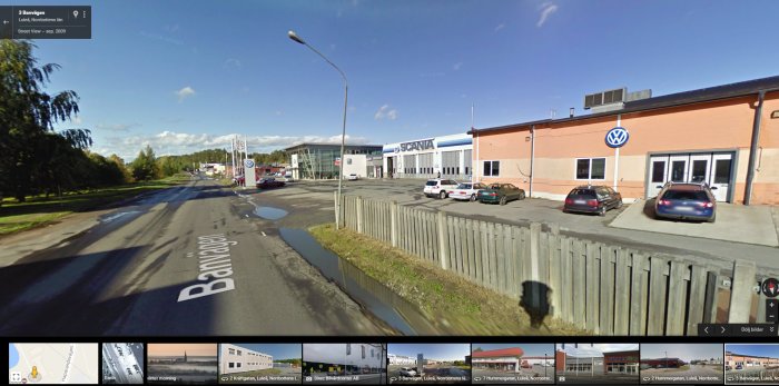 Vy över Banvägen med en VW-skylt vid en bilfirma, där en olycka inträffade vid utkörning på vägen.