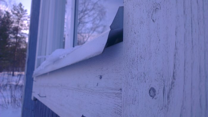 Glipa mellan nedre fönsterfoder och fönsterbleck på en husvägg.