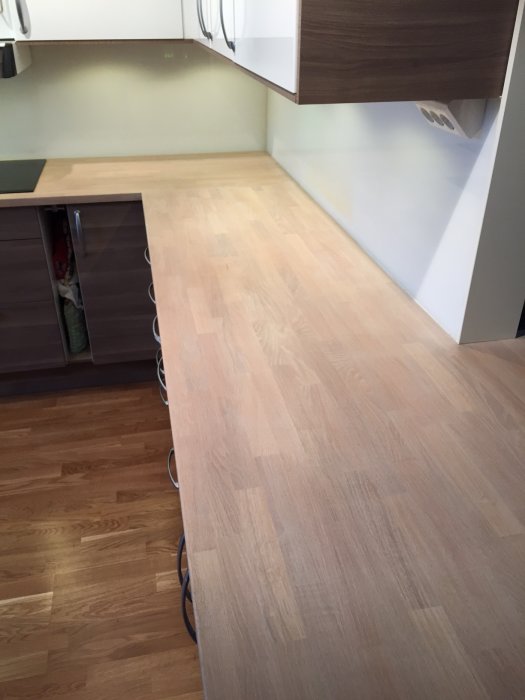 Nyslipad och behandlad träbänkskiva i kök med ljus, matt yta och vita pigment, efter renovering.