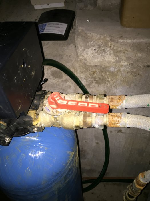 Rostig kulventil och slangar anslutna till en hydrofor i ett vattensystem.