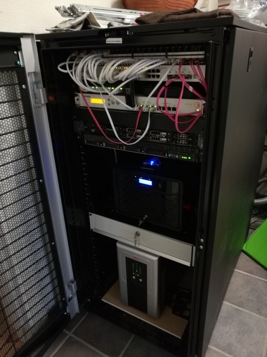 Datacenter i tvättstuga med nätverksskåp, patchpaneler, kablar och servrar.