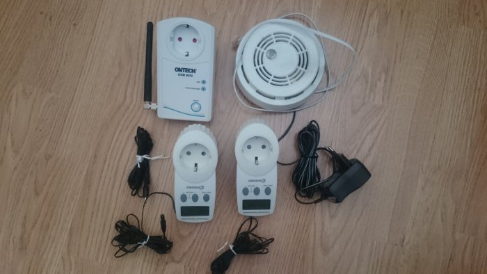 Ontech GSM 9035 larmsensor, två digitala timers och rökvarnare på trägolv.