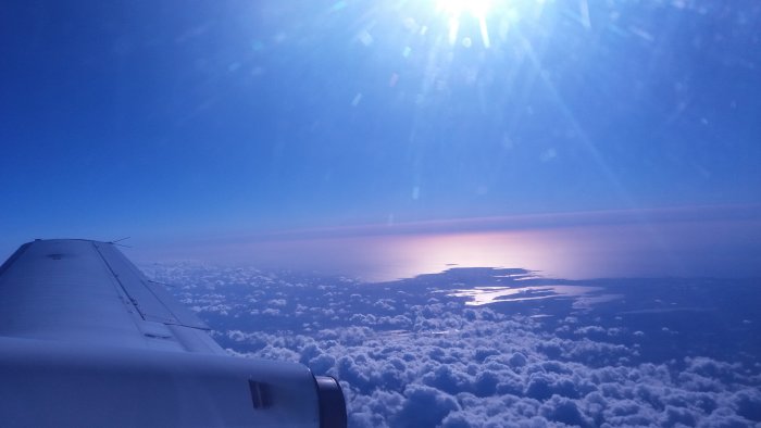 Flygfoto över moln med Ivösjön och gränsen mellan Skåne och Blekinge synlig i solljuset.