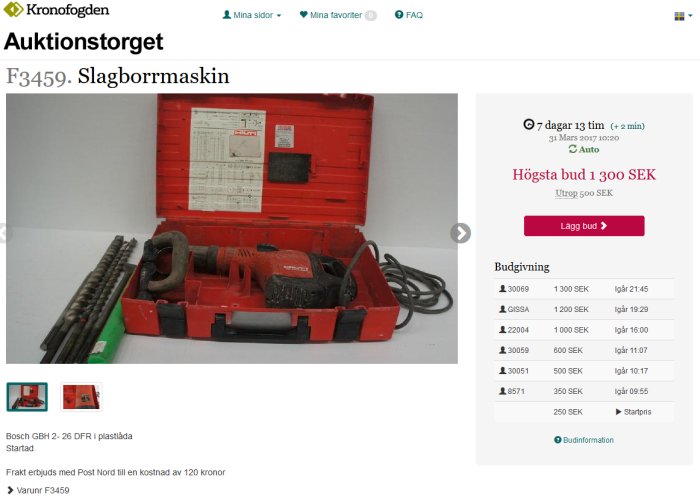 Bosch slagborrmaskin i röd plastlåda med borr och tillbehör, annonserad på en auktionswebbplats.
