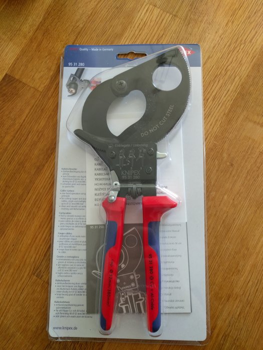 Knipex-tång för kabelkapning i förpackning på träbord.