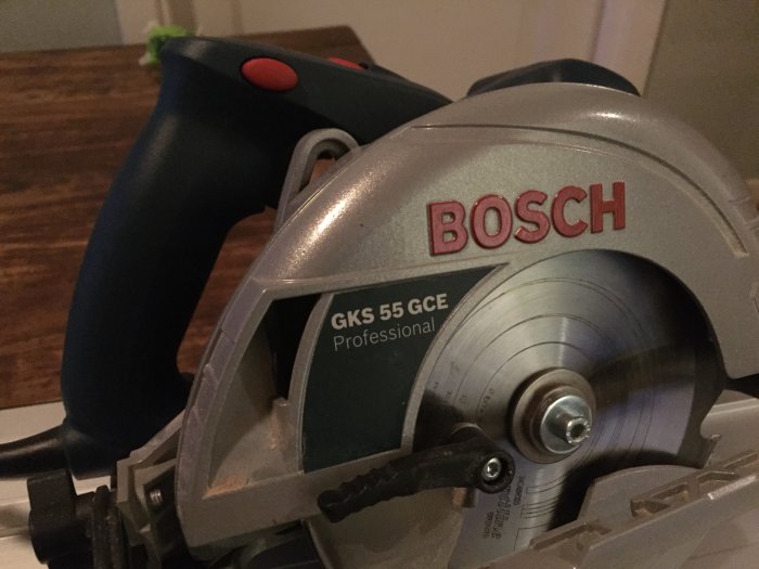 Närbild på Bosch cirkelsåg GKS 55 GCE Professional mot träbakgrund