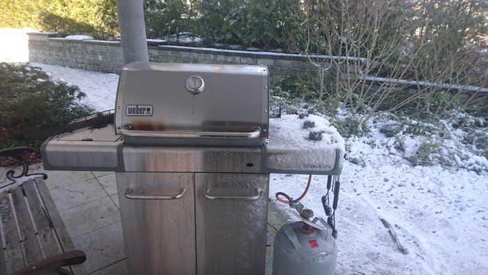 Använd Weber Genesis gasolgrill täckt av snö utomhus utan skydd.