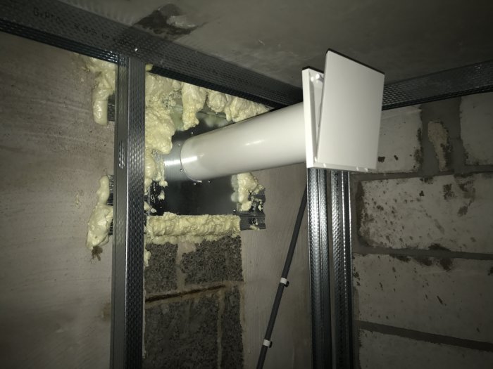 Installation av ventilation i tak med vita rör, isolering och metallstänger.