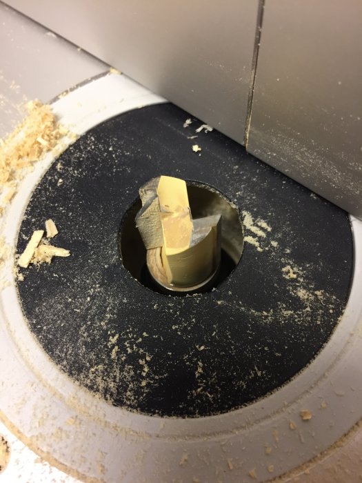 Bild på en trasig Axcaliber Flush Trim Cutter i en fräsmaskin omgiven av träspån.