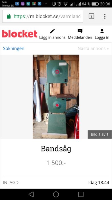 En begagnad grön bandsåg utan anhåll visas i ett skjul.