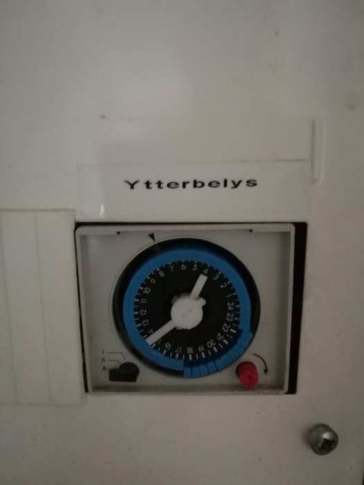 Analog timer för ytterbelysning med en blå och vit urtavla och mekaniska inställningsknappar.