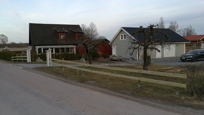 Nytt trästaket längs en tomt och renoverat hjul på en garages vägg.