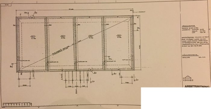 Ritning av grunden till ett kedjehus med måttangivelser och markerad potentiell borrplats för radonsanering.