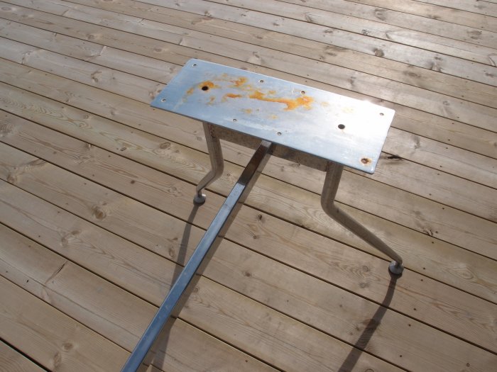 Fuktskadat och rostat gammalt metallbord på en träaltan.