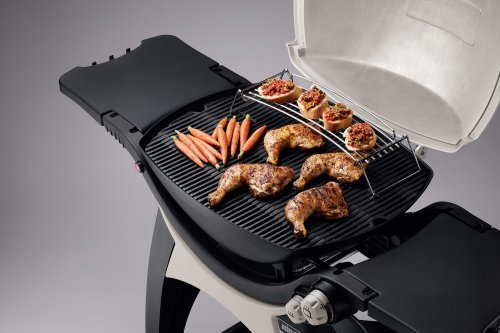 Grill med kycklingdelar och grönsaker, locket är halvöppet med generöst utrymme över maten.