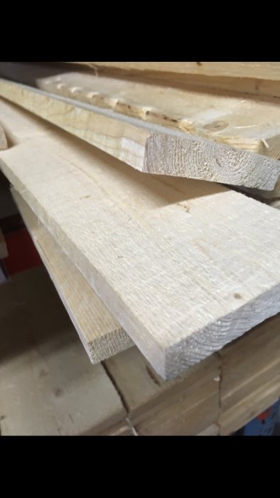 Ohyvlade trädbrädor av storlek 19x100mm staplade på varandra i en byggmarknad.