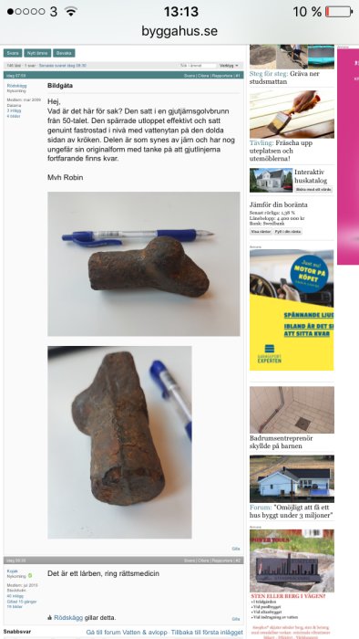 Gammal järnbit med rost som ligger på ett vitt underlag, jämförd i storlek med en blå kulspetspenna.