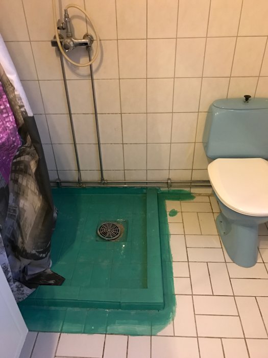 Renoverat badrum med tätskikt applicerat på gammalt klinkergolv och runt golvbrunn.
