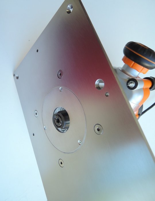 Metallplatta med cirkulärt hål och infästningar, skruvmejsel i bakgrunden.