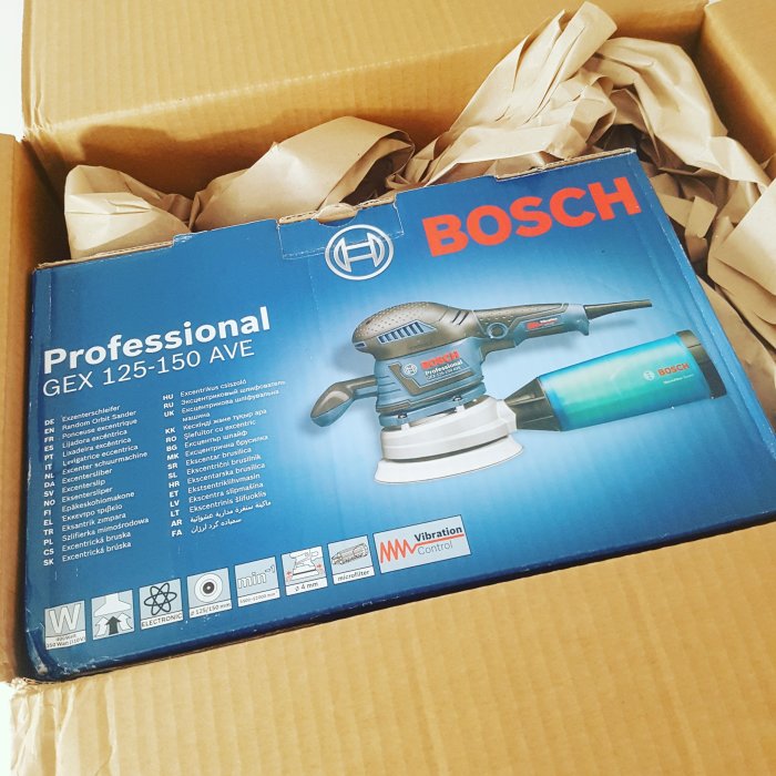 En ny Bosch slipmaskin modell GEX 125-150 AVE i förpackning, oöppnad kartong med packpapper.