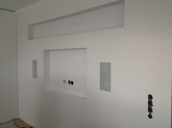 Vägg med förberedelse för infällnad av TV, synlig elinstallation och nätverksuttag.