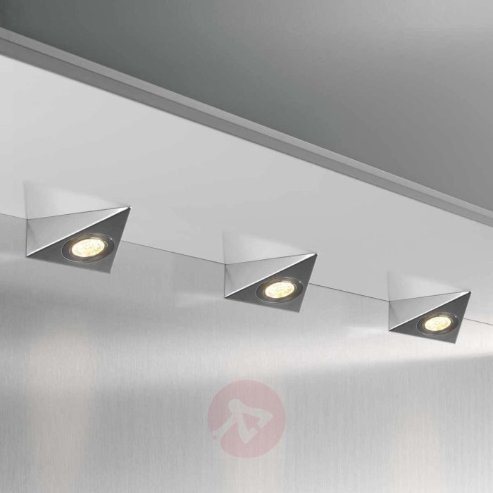 Fyra LED-spotlights inbyggda i ett kökstak som ger direktljus på den blanka bänkskivan nedanför.
