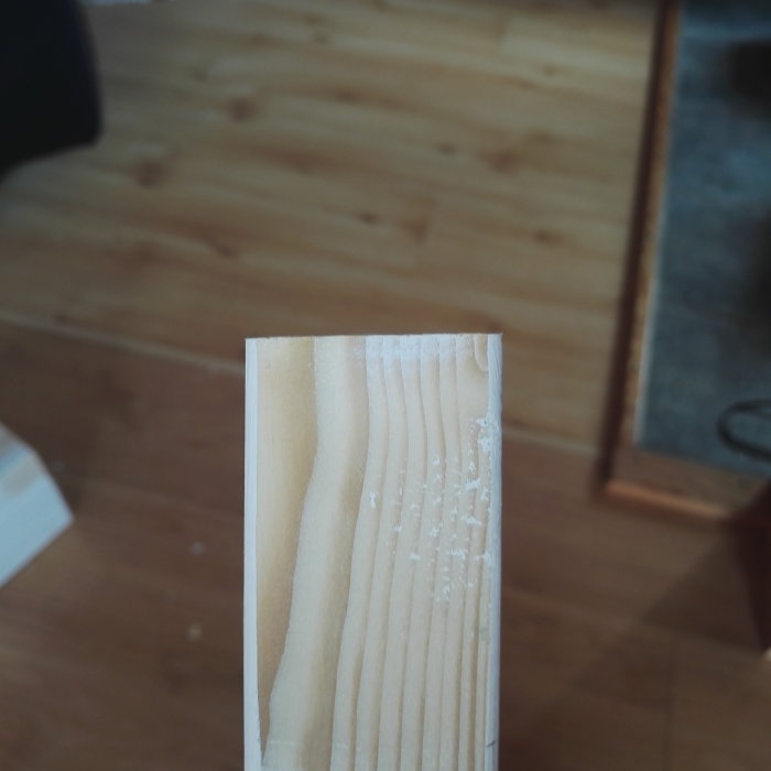 Ojämnt sågat trästycke med fransiga och oregelbundna snittkanter.