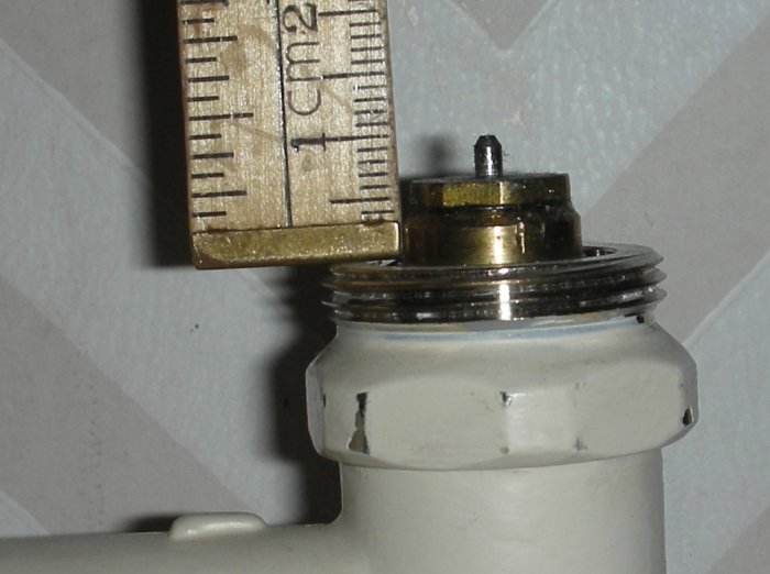 Tumstock mäter gängan på en gammal radiatorventil för att identifiera storleken för installation av ställdon.