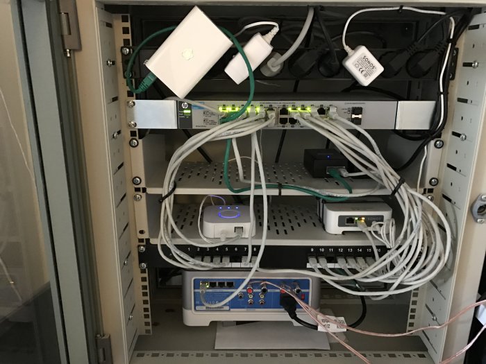 En nätverksuppställning med fiberomvandlare, server, switch och VLAN-utrustning i ett skåp.