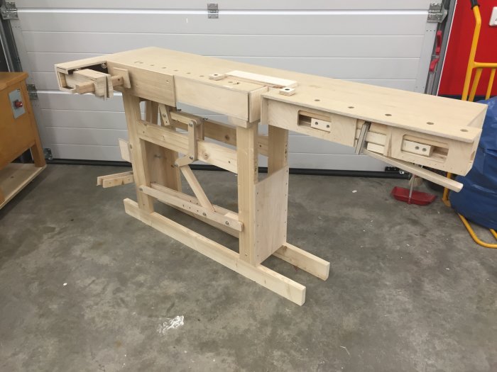 Träsvarvbänk av plywood i en verkstad, utan någon person synlig.