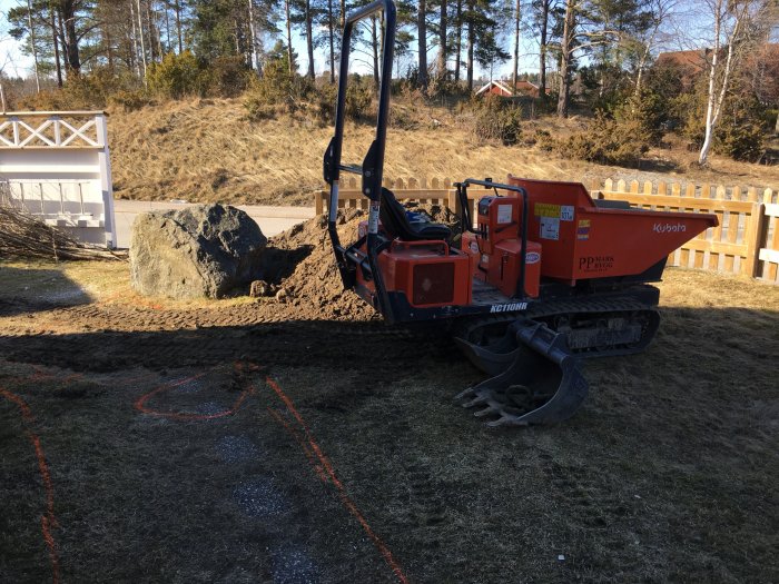 Minigrävare och minidumper på en trång villatomt, mark markerad för anläggning.