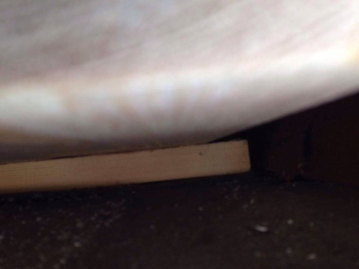 En suddig bild under tak där råspont och läkt syns, eventuellt en del av renovering.