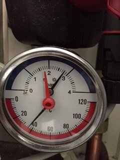 Manometer med röd visare som pekar strax över 2,5 bar indikerande högt tryck i värmesystem.