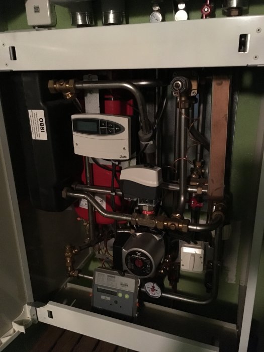 Fjärrvärmecentral Logstor typ med Danfoss ECL110 reglerenhet, synliga rör och komponenter.