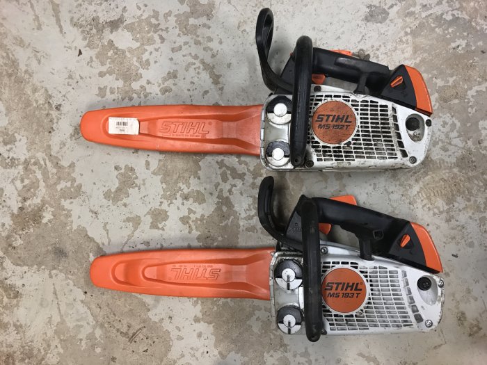 Två Stihl motorsågar på ett betonggolv sedda uppifrån.