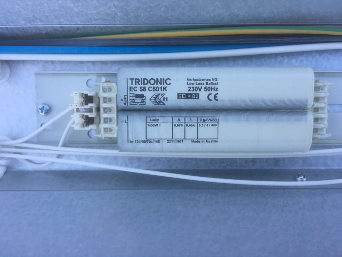 Tridonic elektroniskt driftdon för lysrör utan täckglas, med synliga anslutningar och kablar för koppling.