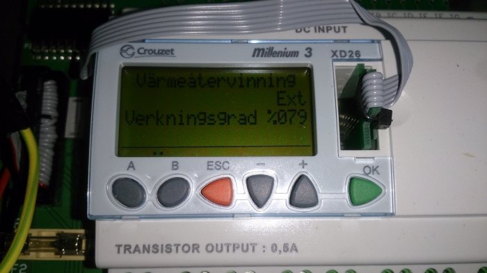 LCD-display på ett ventilationssystem visar texten "Värmeåtervinning" och "Verkningsgrad 87.9".