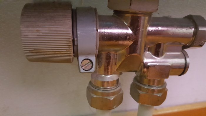 Avbrutet termostatvred på radiator med synlig klämkoppling från 70-talet.