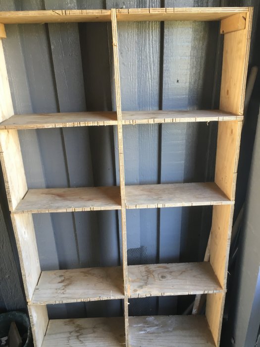 Hemmagjort sågbord av plywood med fackverksdesign och förstärkta hörn, placerat mot en blågrå vägg.