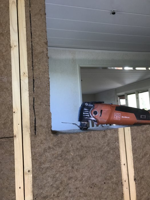 Elektrisk såg skär genom OSB-skiva mot träreglar i ett byggprojekt inne i ett hus.