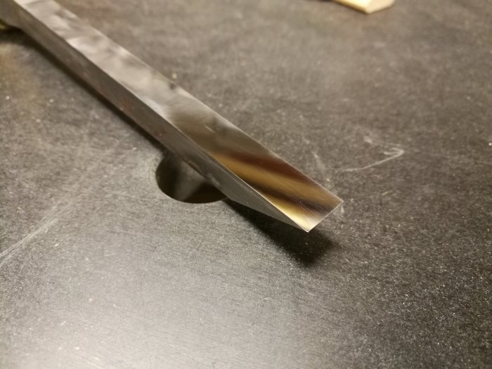 Närbild av Narex lockbettel i storlek 10mm med synlig slitage och fläckig finish på en mörk arbetsyta.
