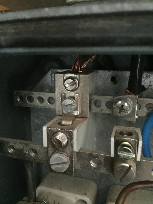 Elektrisk koppling i gruppcentral med en lös PEN-ledare och en sliten skruv.