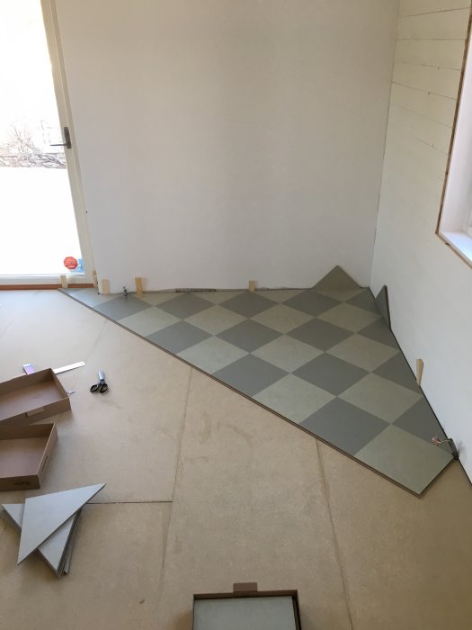 Installation av Marmoleum click-golv i ett mönstrat och halvfärdigt läge med verktyg och material synliga.